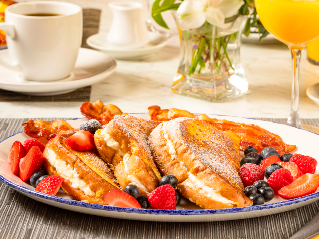 Brio's french toast, fresh fruit, and bacon brunch meal with coffee and mimosa