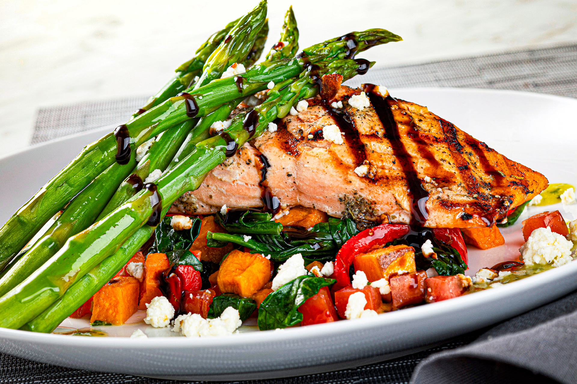 Grilled salmon with asparagus on a bed of vegetables