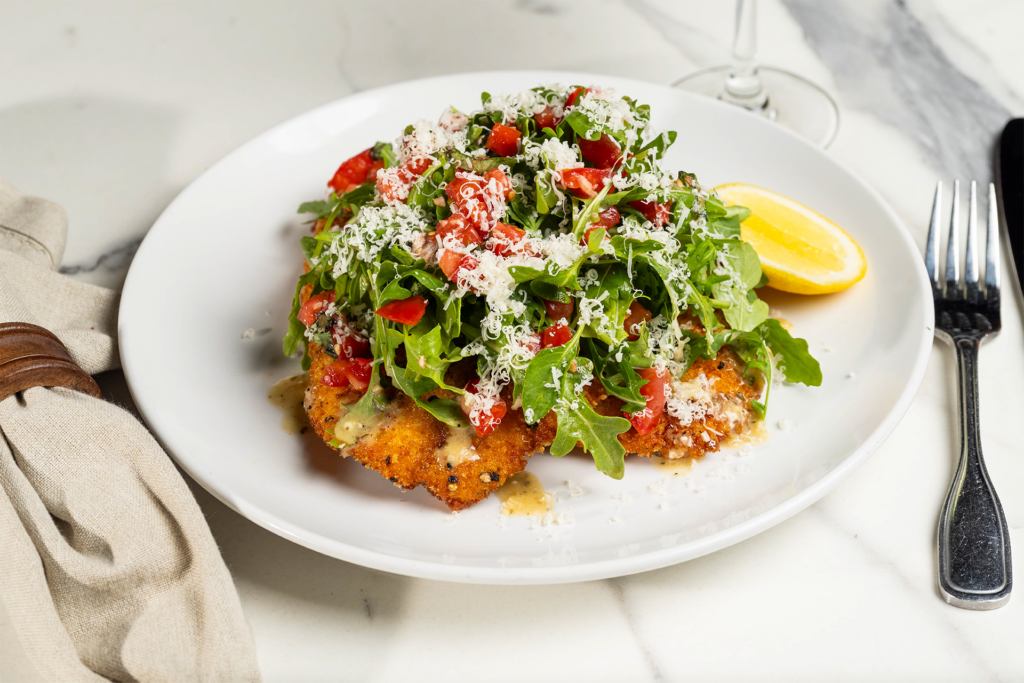 Crispy lemon chicken topped with arugula, tomatoes and cheese.
